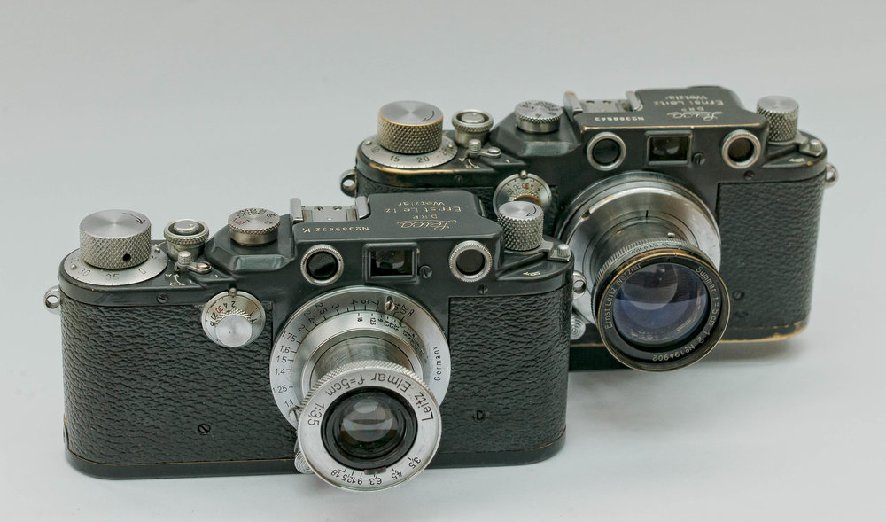   Two war-time IIIc models with grey paint. The one in front is a  K model , designed for cold  weather and incorporating a special ball-bearing shutter for low-temperature reliabiliy. The K represents Kugellager or ball-bearing. They were produced mainly for the Luftwaffe (Image William Fagan)  